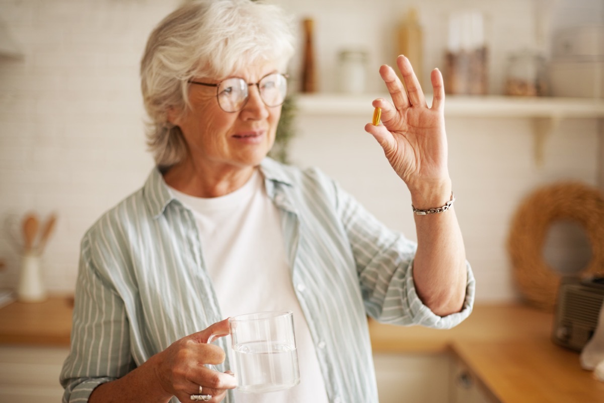 Woman taking a pill or a supplement