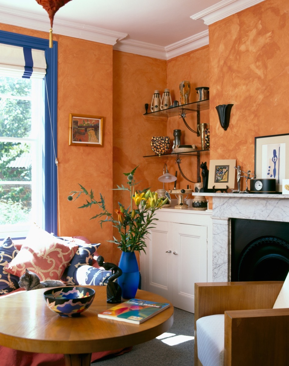 Spongeing paint effect on the walls of nineties living room with circular coffee table