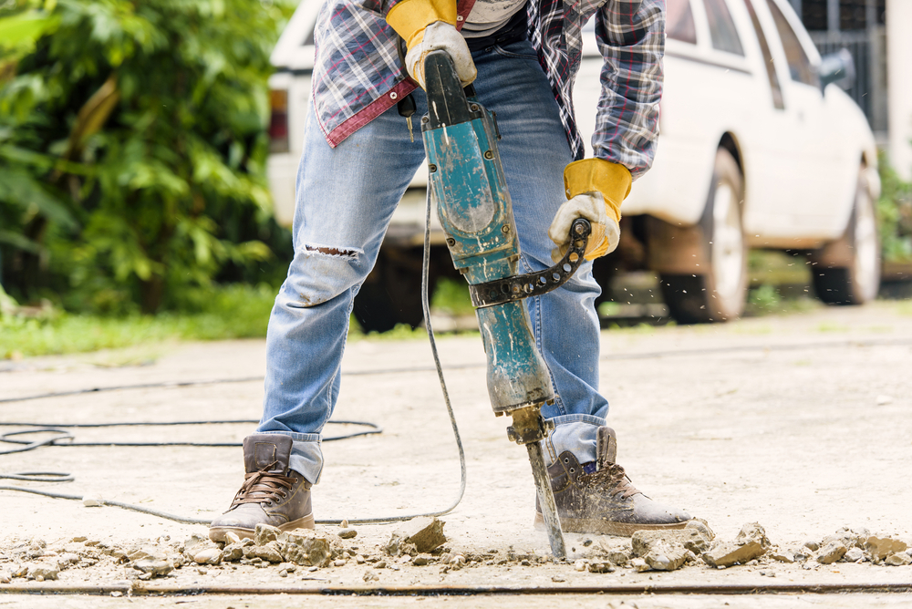 A close up of a construction worker using a jackhammer