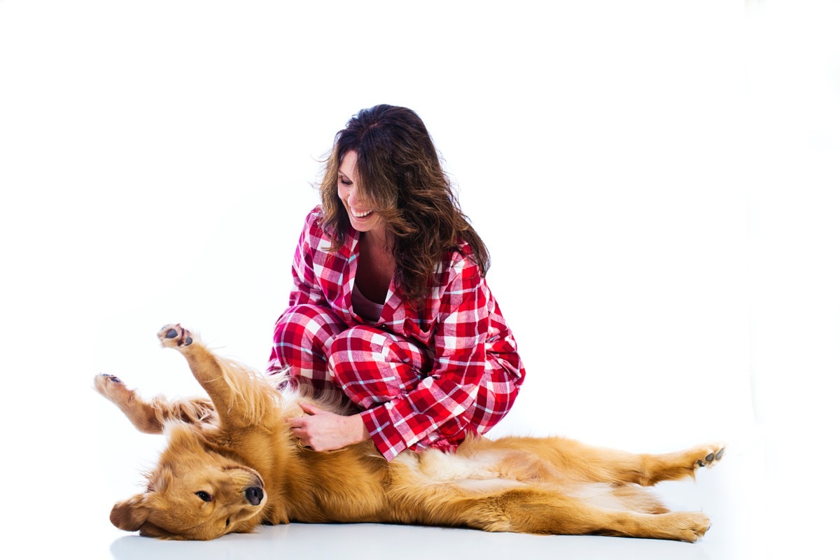 Woman rubbing dog's belly