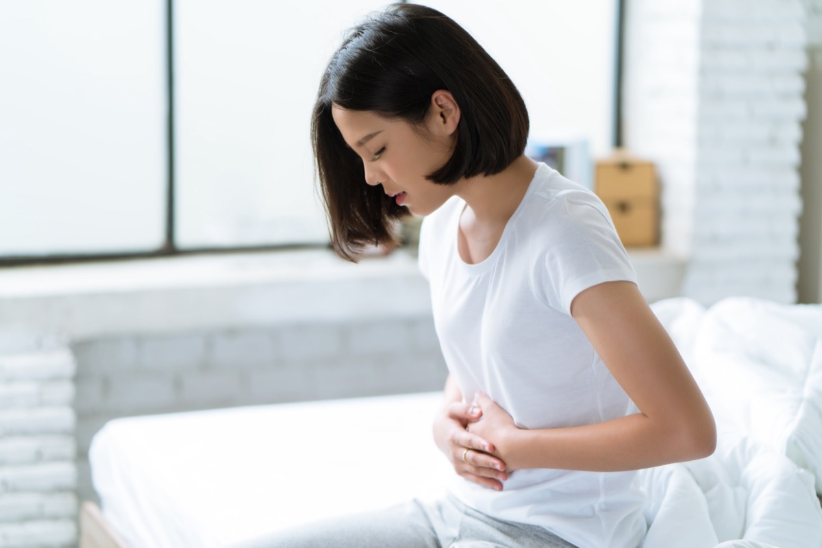 Woman touches her stomach.