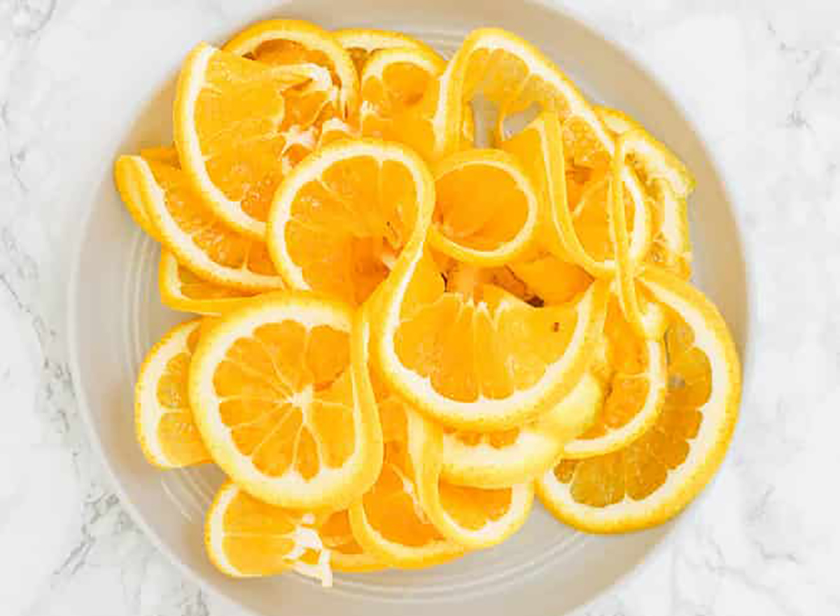 spiralized oranges on a grey plate on a marble counter top