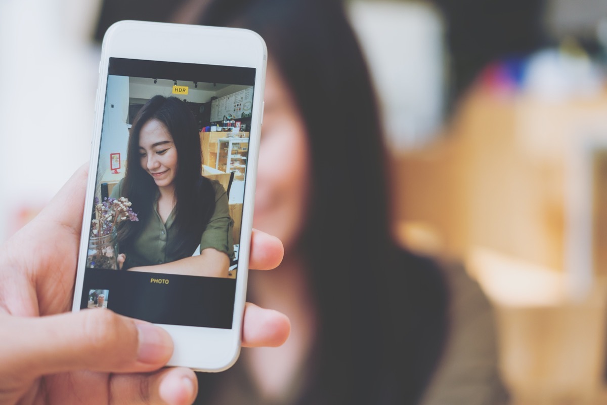 woman taking candid photo of her friend things women do with their friends