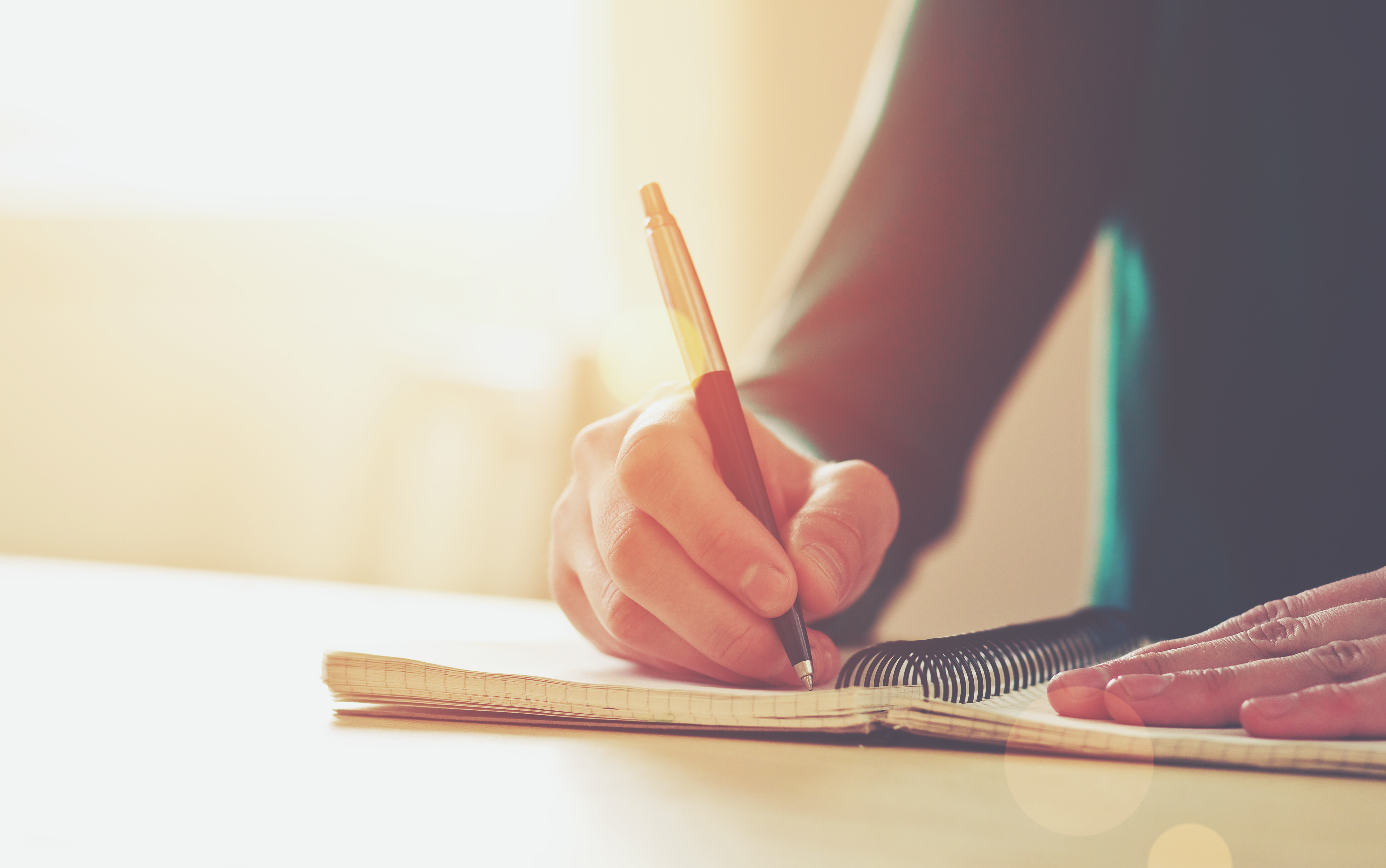 man writing in notebook