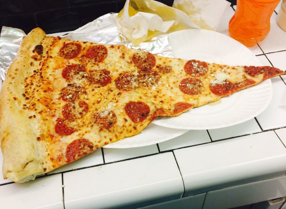 jumbo pizza slice with pepperoni on two plates in Washington d.c.