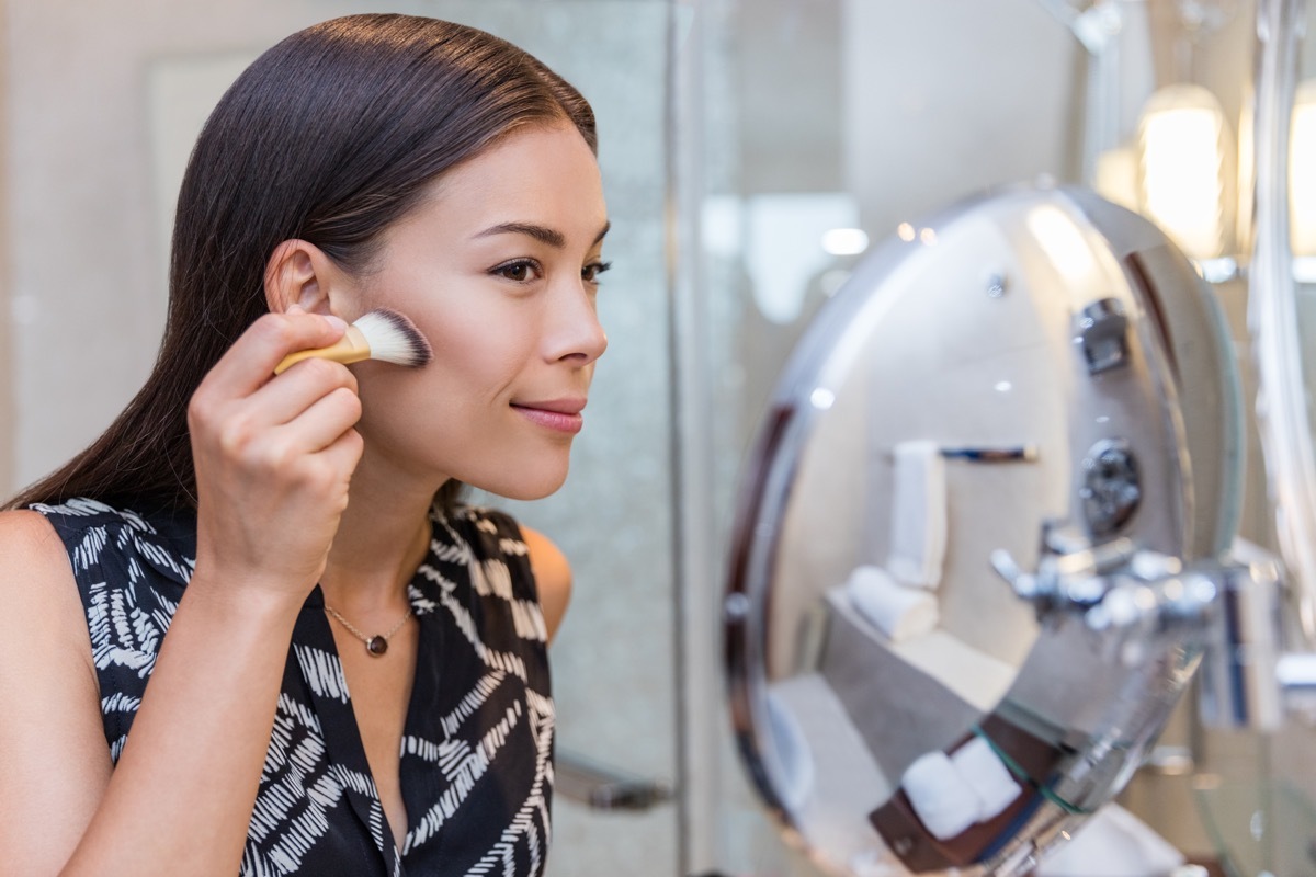 Woman applying bronzer makeup