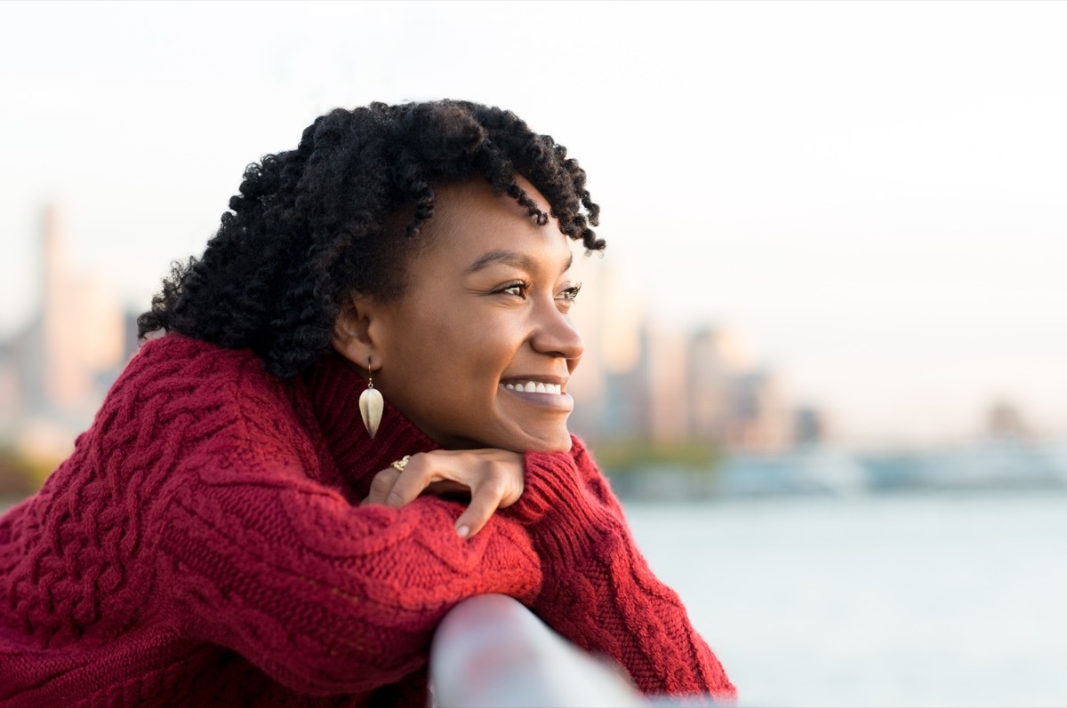 woman thinking and smiling on the side of a brige