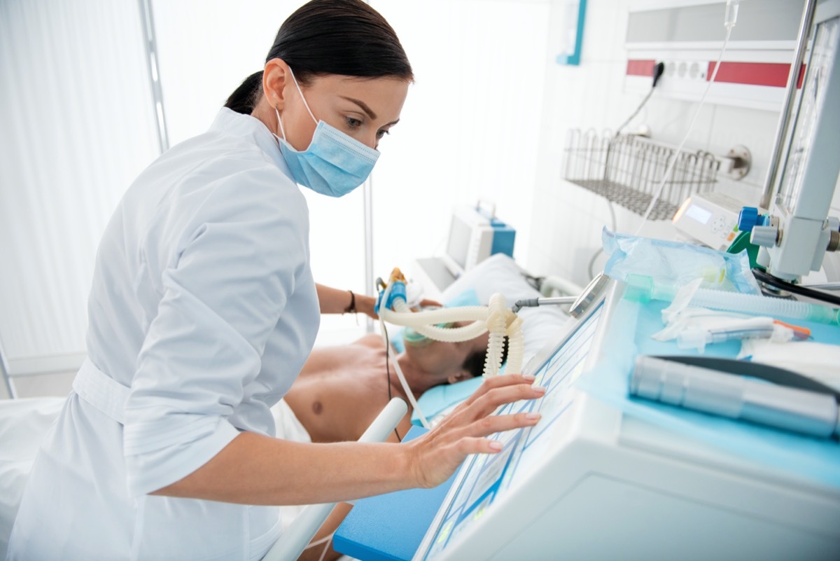 young white female doctor treating patient on ventilator