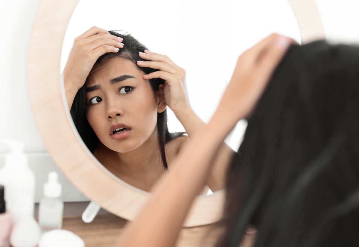 Woman checking hair in mirror