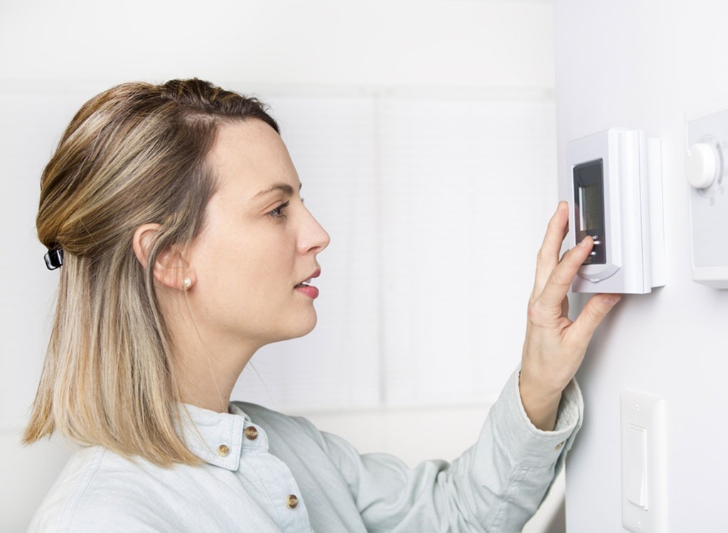 woman checking thermostat