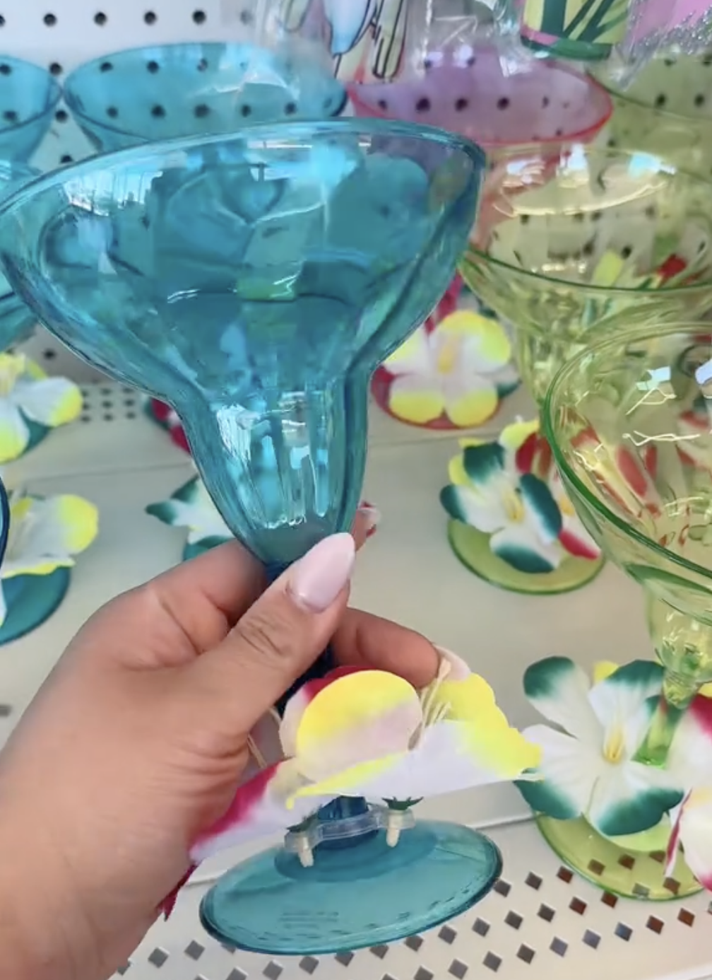 Shopper holding plastic margarita cups in Dollar Tree