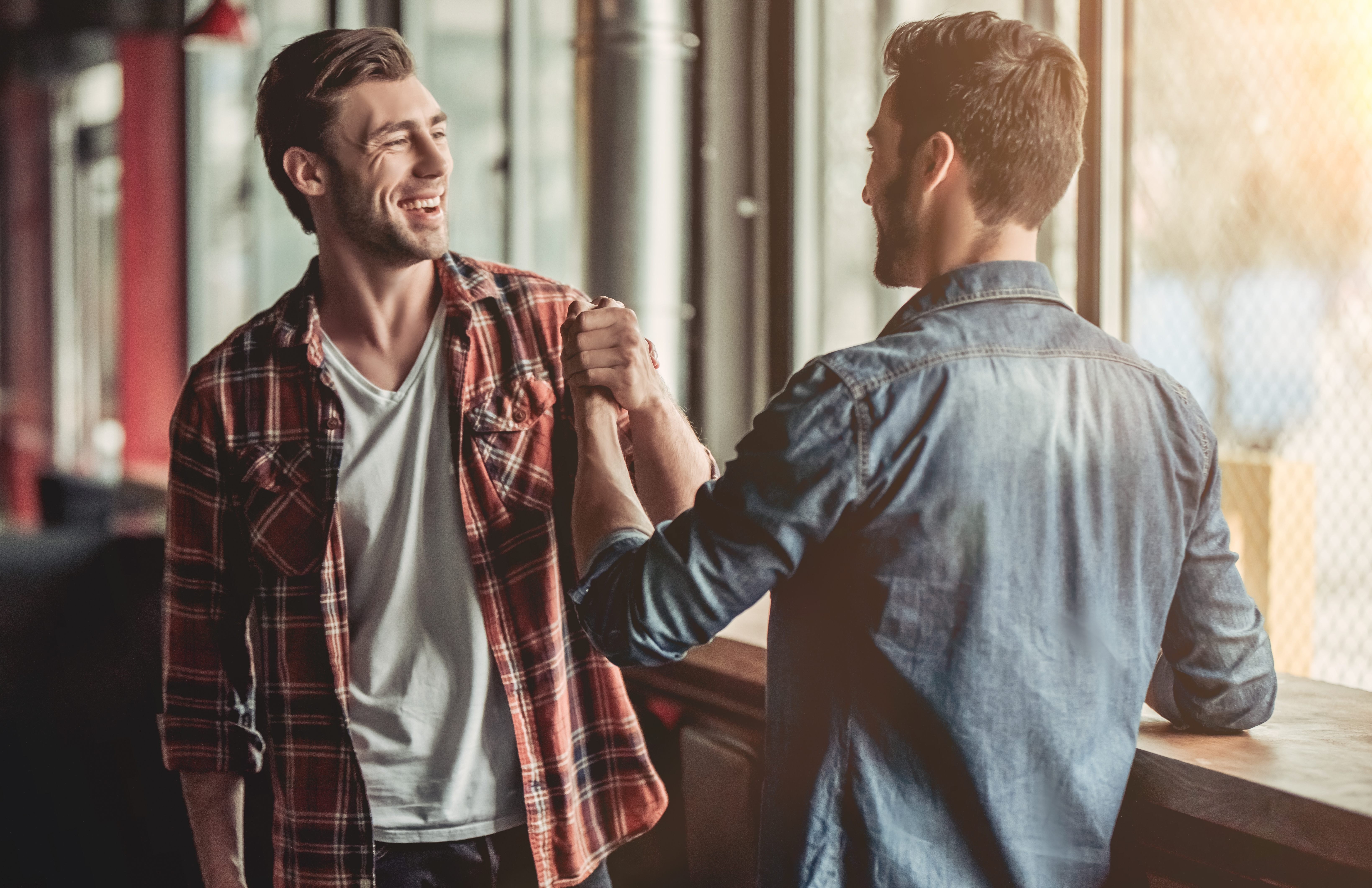 two friends greeting each other in a bar