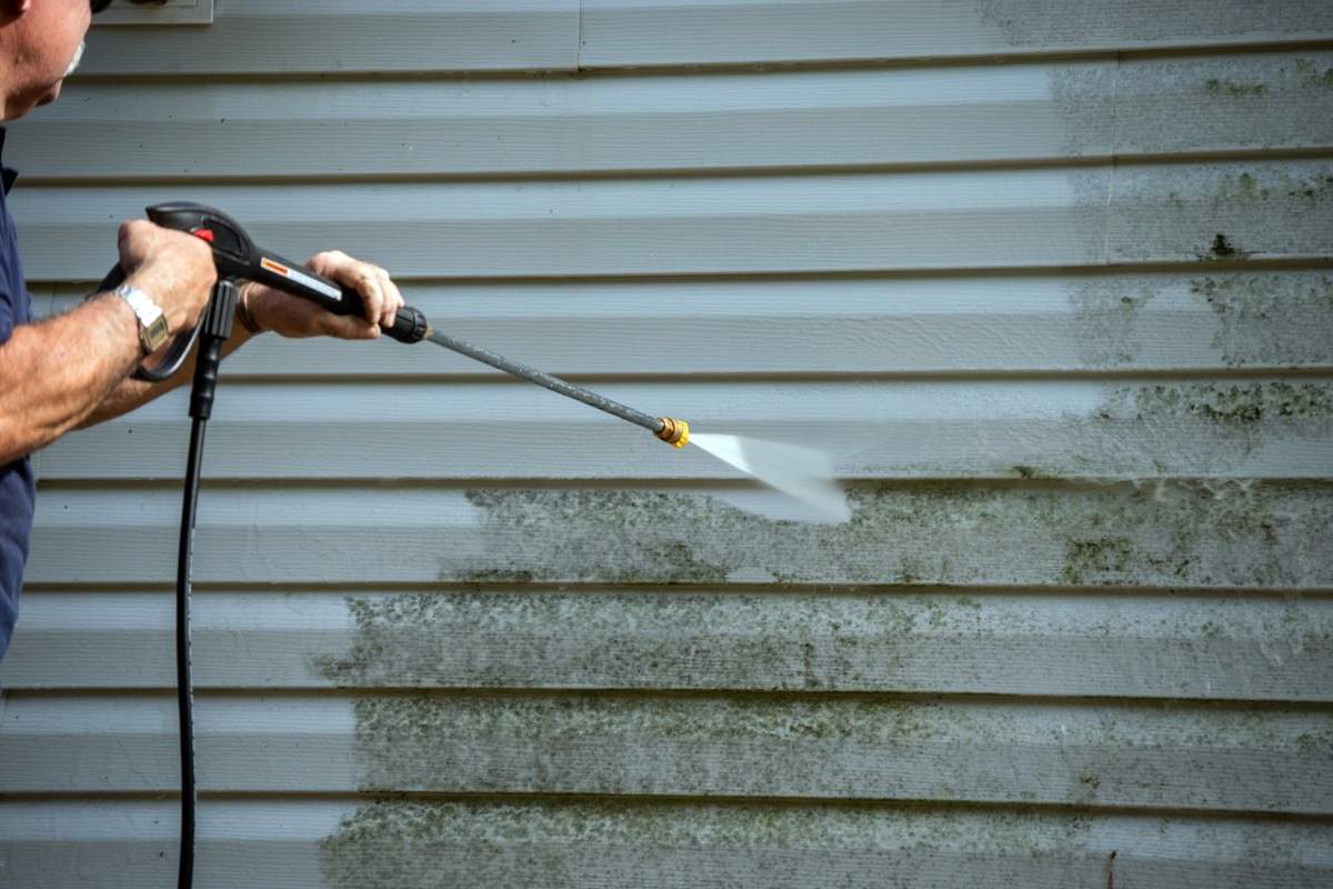 man power washing home siding