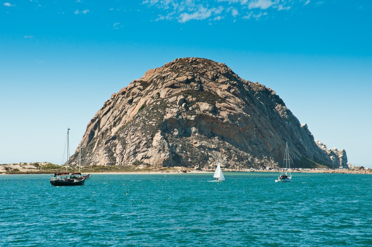 morro bay california with a huge rock formation and sail boats