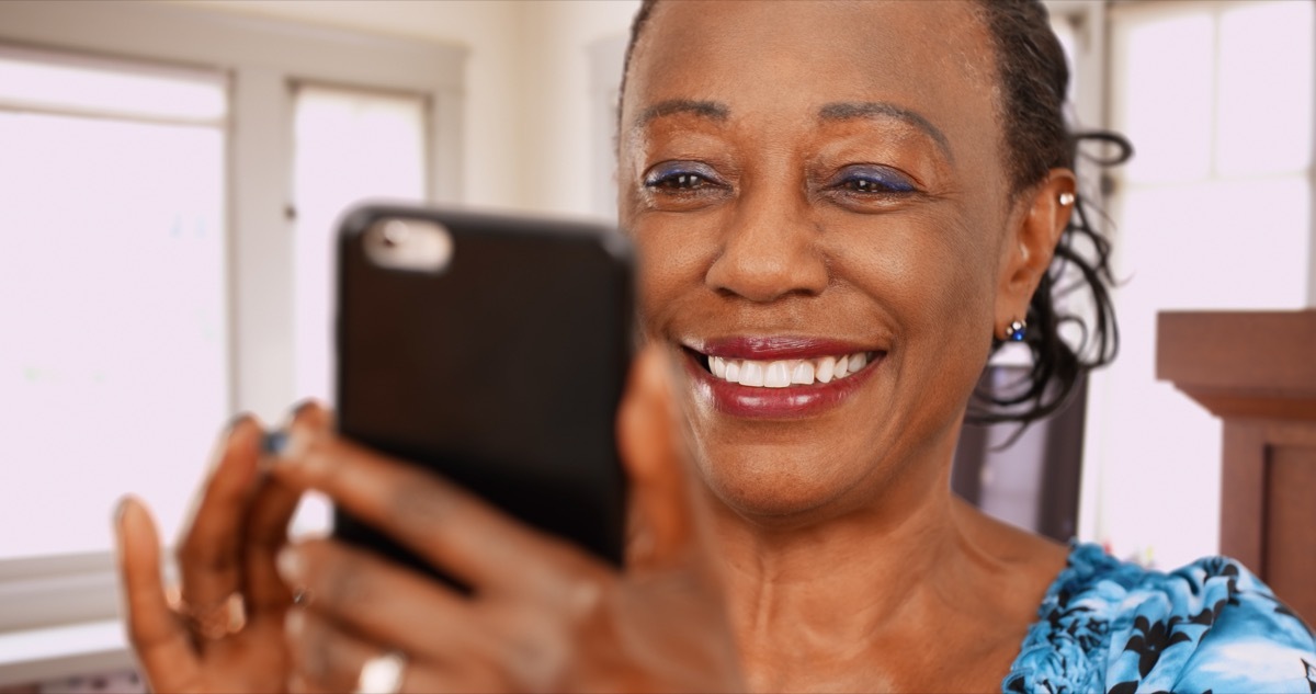 Woman smiling and looking at cell phone