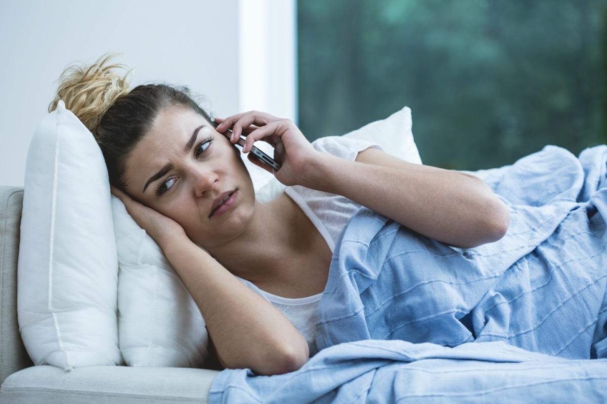 Bad feeling woman lying on the sofa with phone