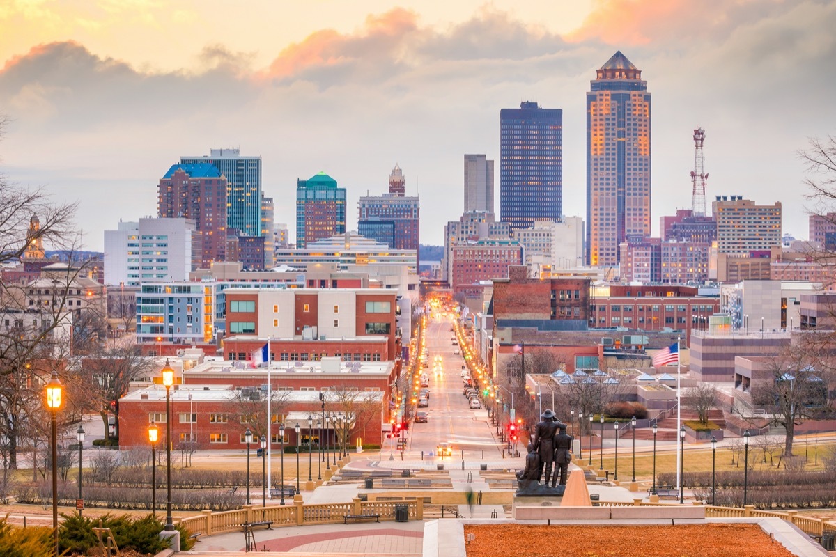 cityscape photo of buildings, a street, and statue from behind in downtown Des Moines, Iowa at dusk