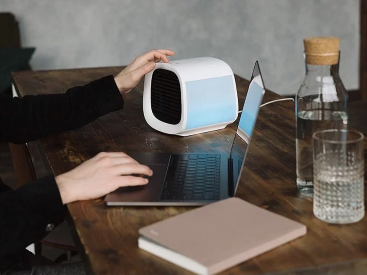 woman touching white box on desk with laptop and notebook, better sleep essentials