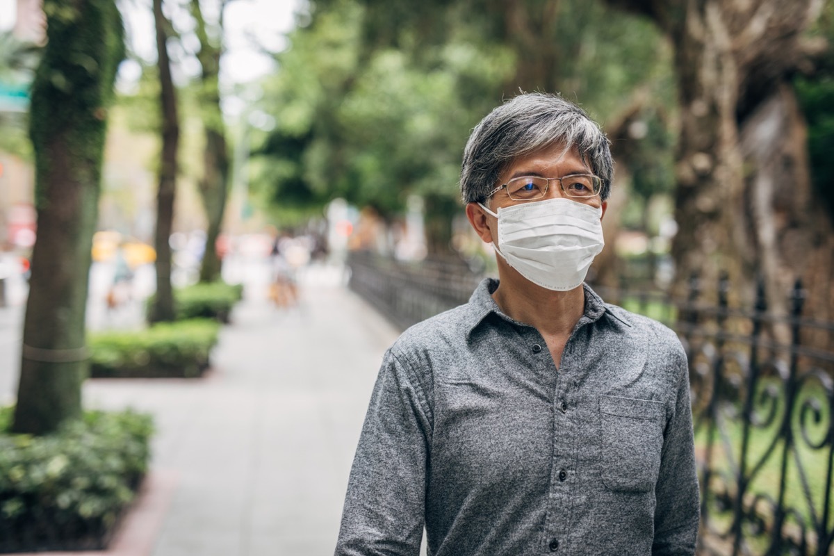 older man walking with face mask outside