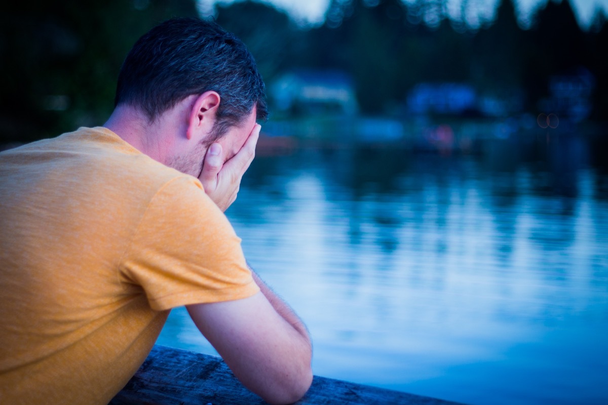 sad man looking out at lake - life choices