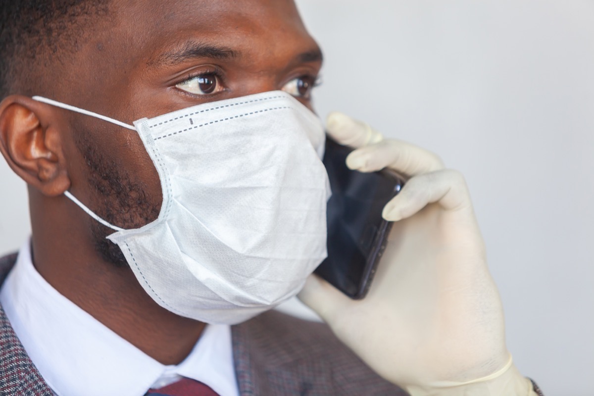 man on phone while wearing gloves and face mask