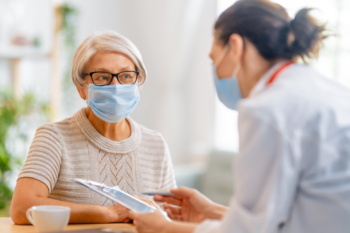 Doctor and senior woman wearing facemasks