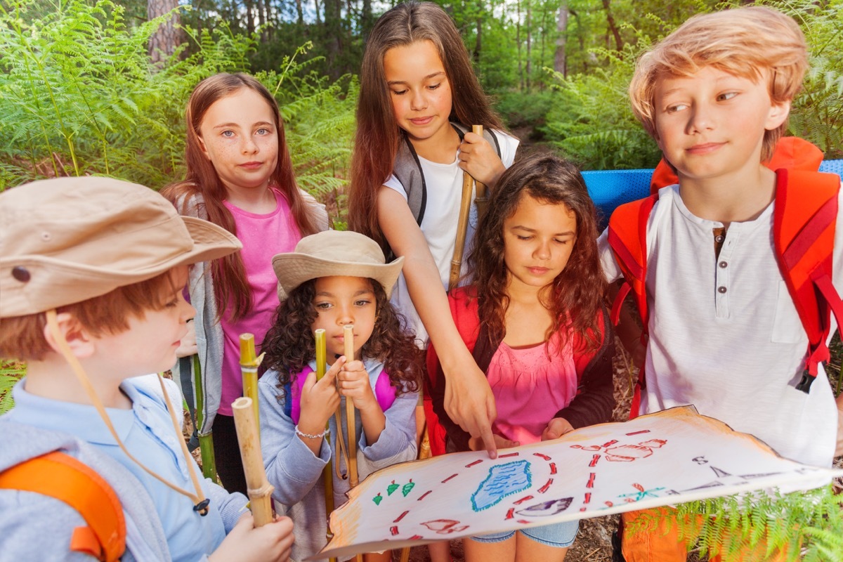 Kids doing a scavenger hunt looking at map