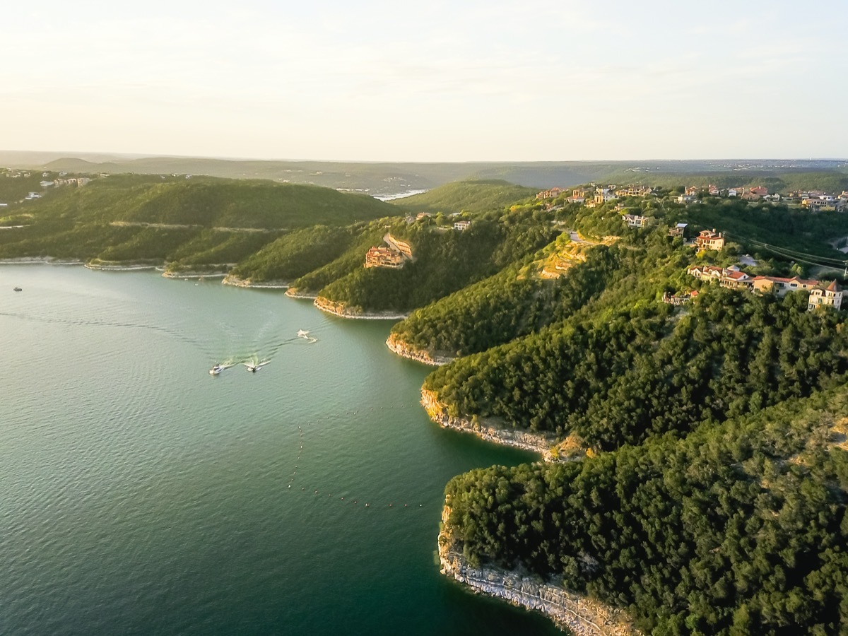 trees on a cliff rock wall and houses at Lake Travis in Austin, Texas