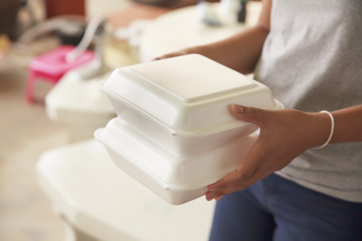 Woman holding styrofoam boxes 