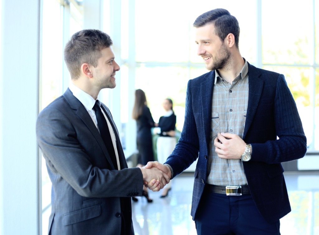 two male colleagues shaking hands in an office