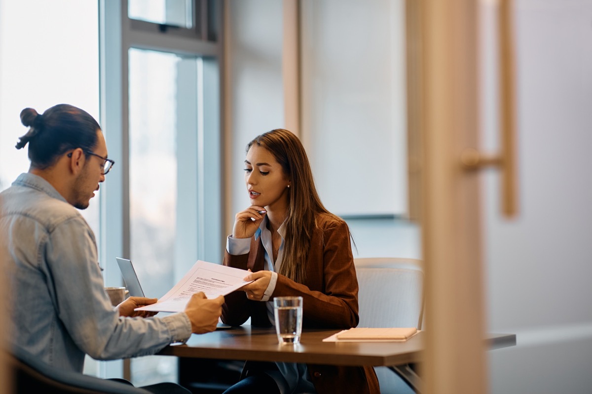 Young businesswoman and her male coworker analyzing reports while working in the office. Copy space.