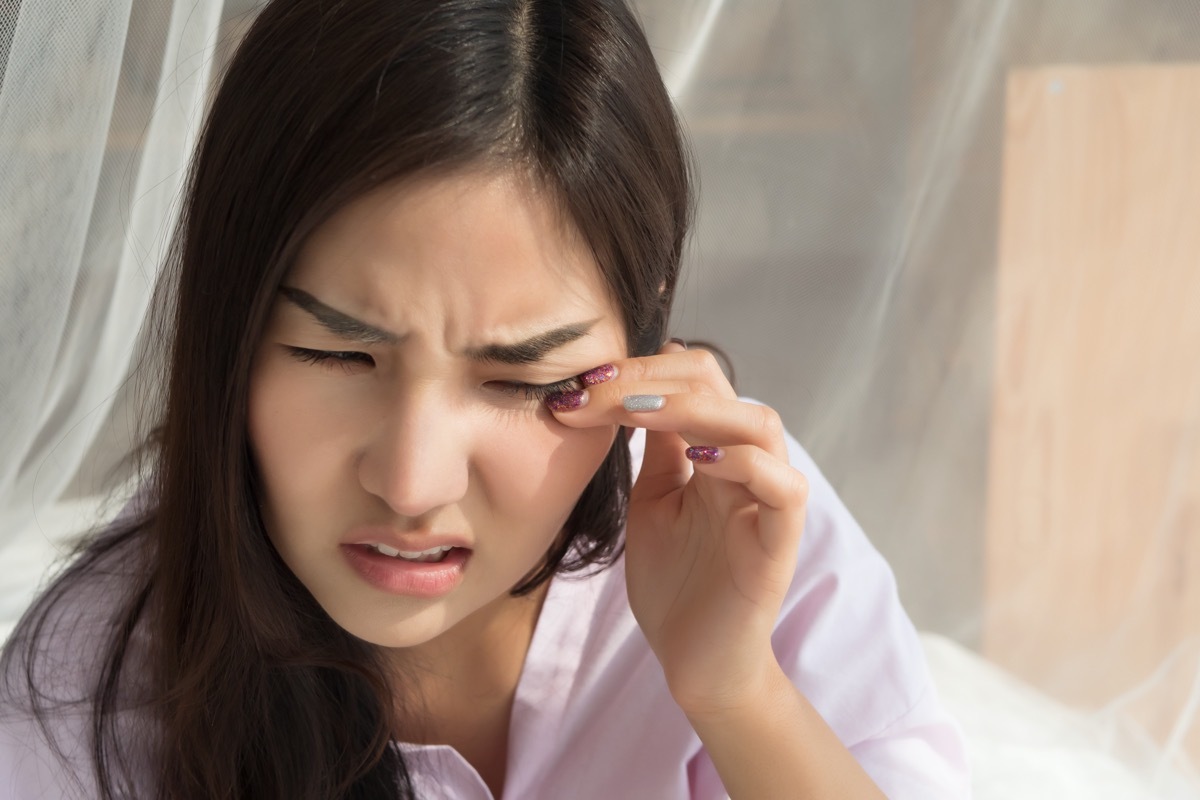 young woman rubbing eye