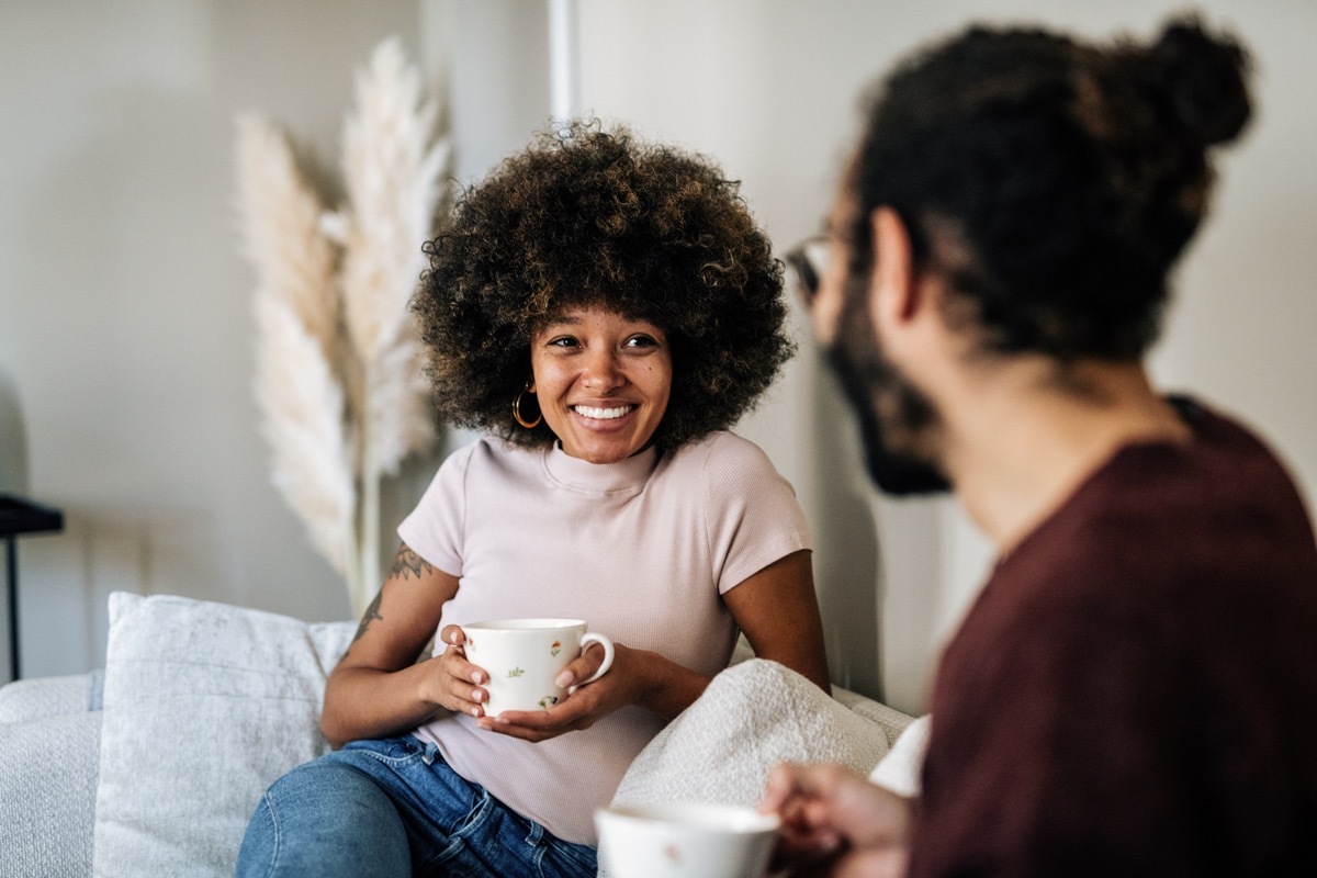 couple in living room drinking coffee or tea