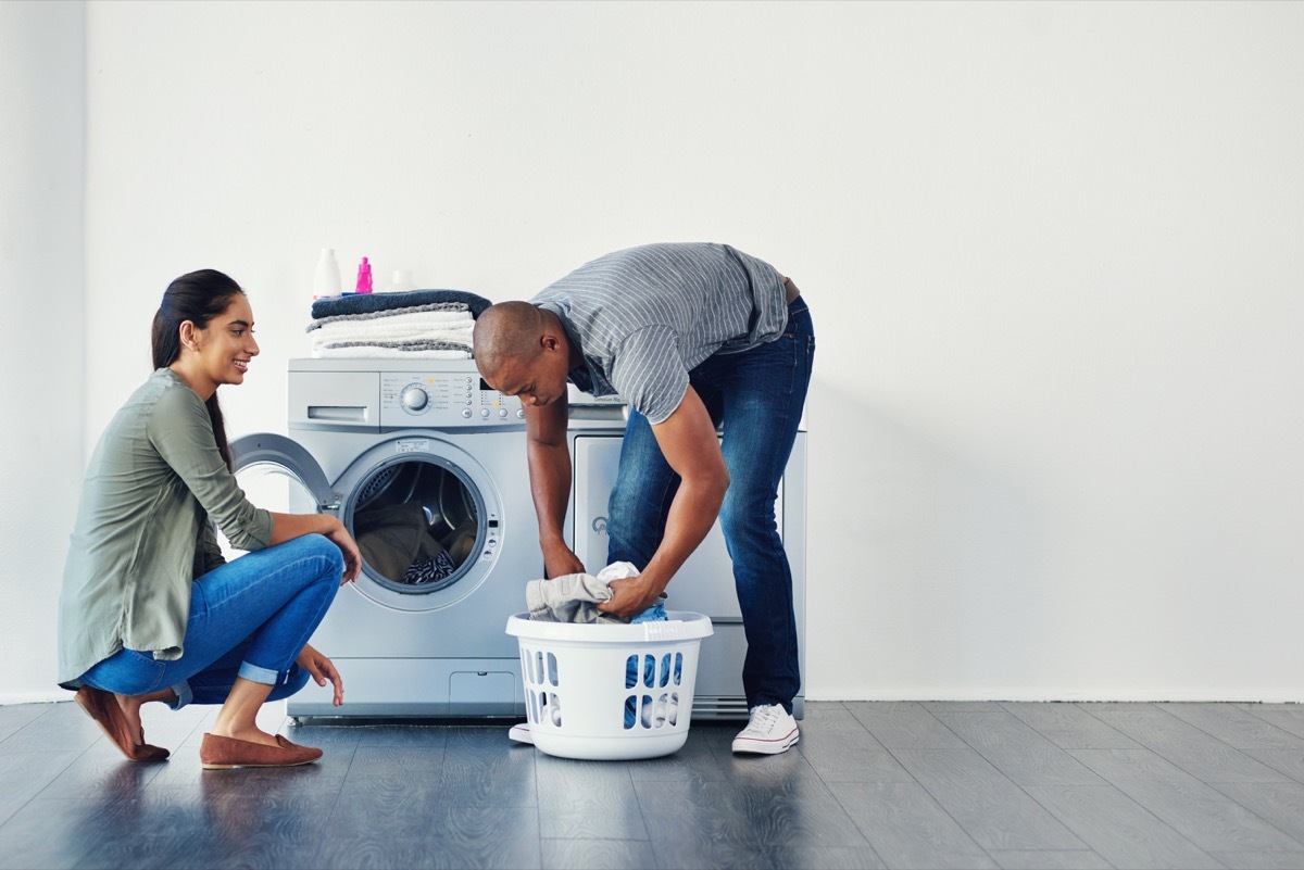 Shot of a young woman doing laundry at home