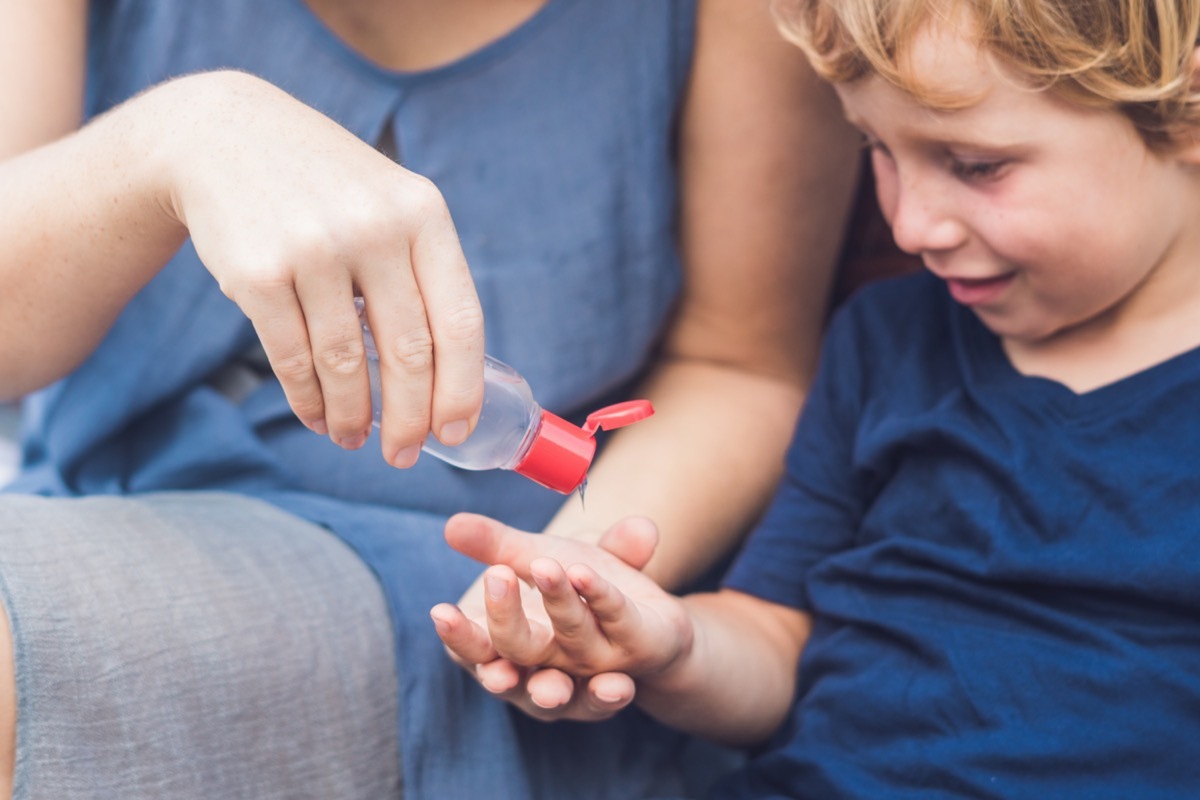 Mother and son using wash hand sanitizer gel pump dispenser