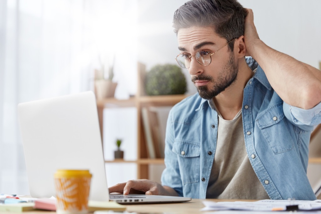 man fidgeting in front of a laptop Things Men Won't Admit