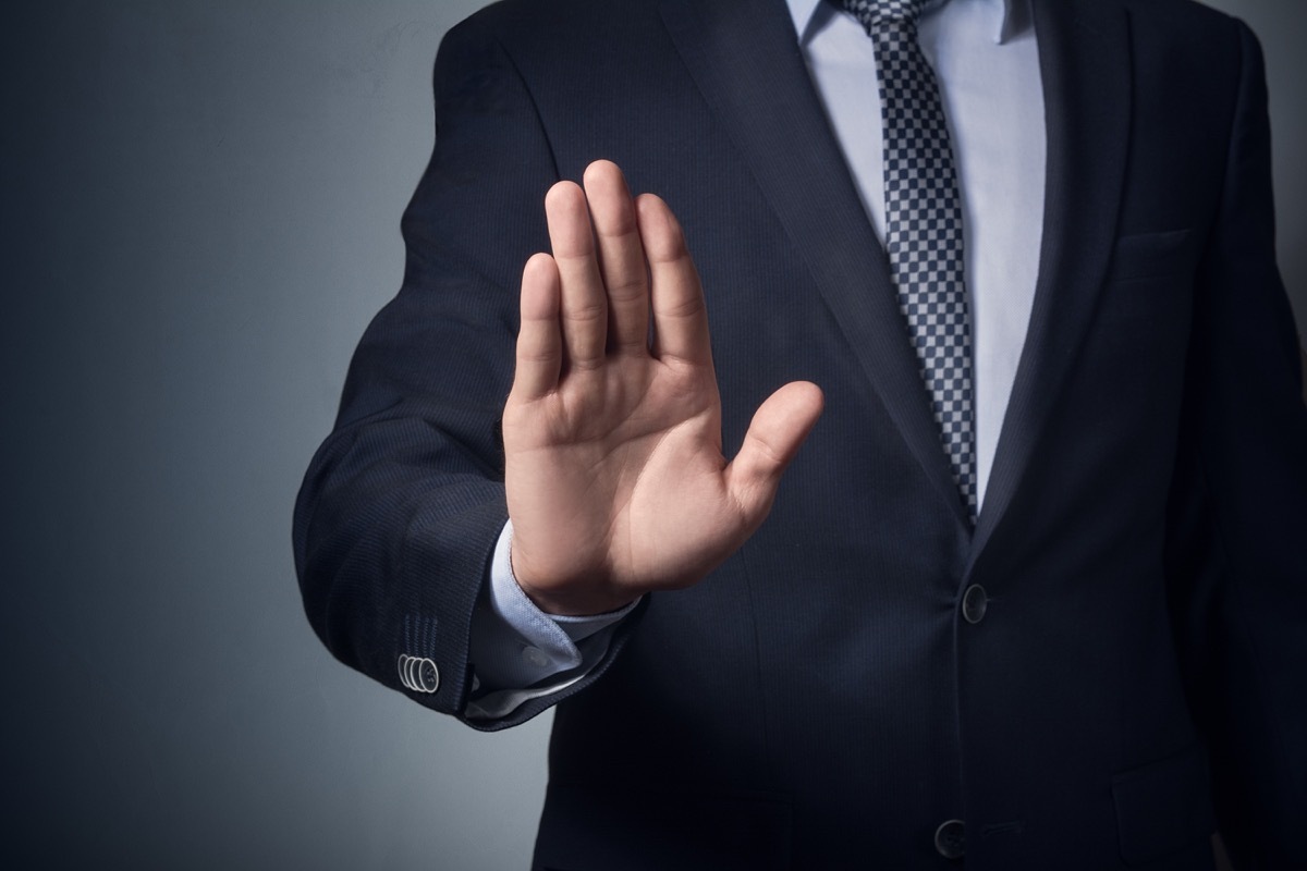 man in suit gesturing stop