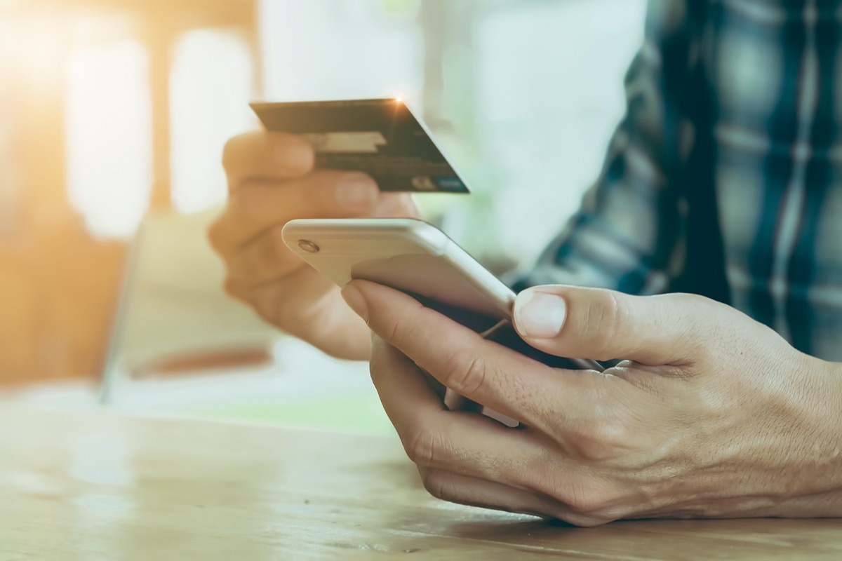 Hands holding credit card and phone