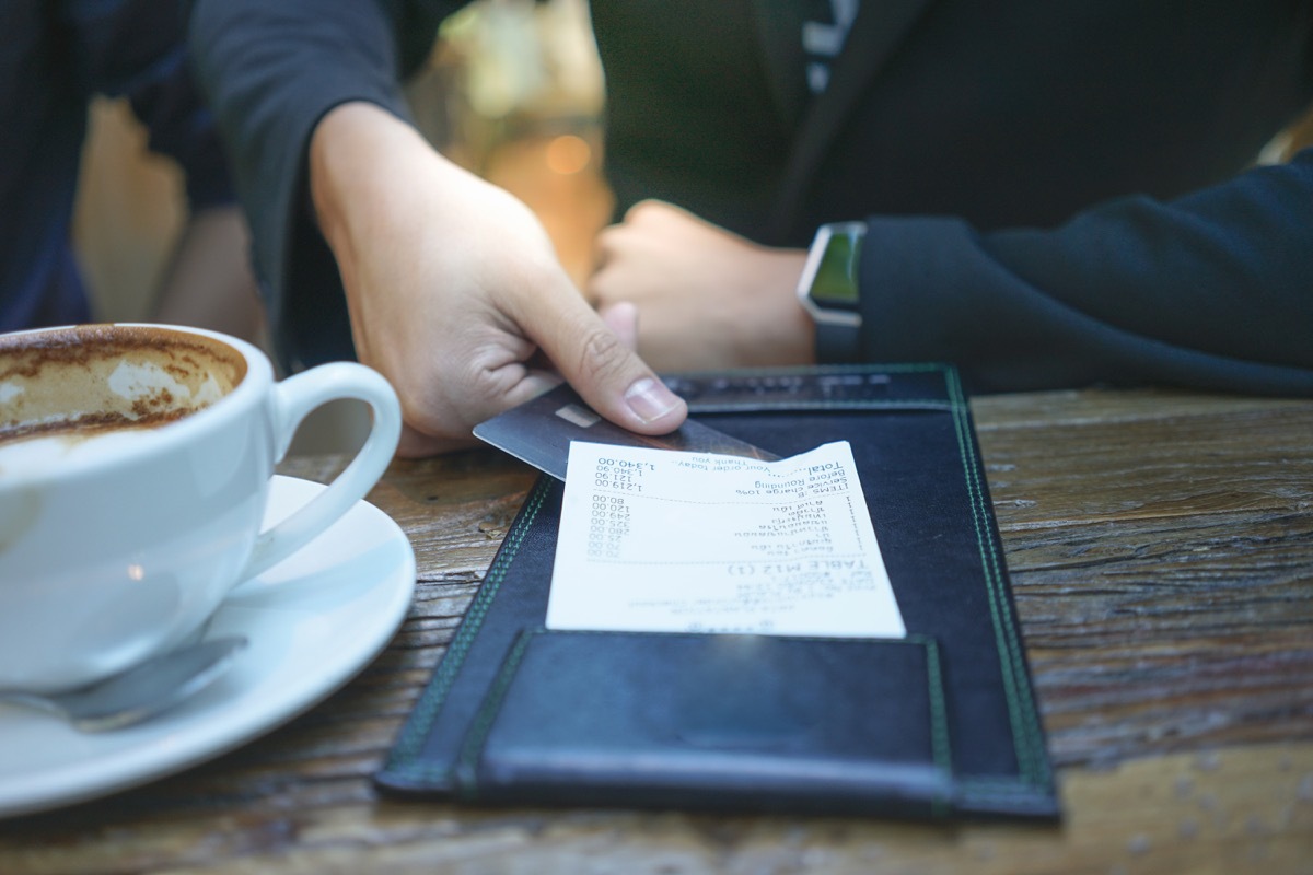 man holding restaurant check