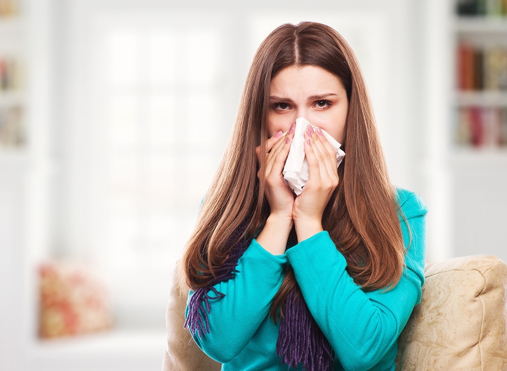 Sick woman blowing her nose