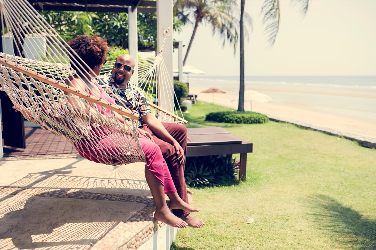 couple sitting in a hammock on a beach