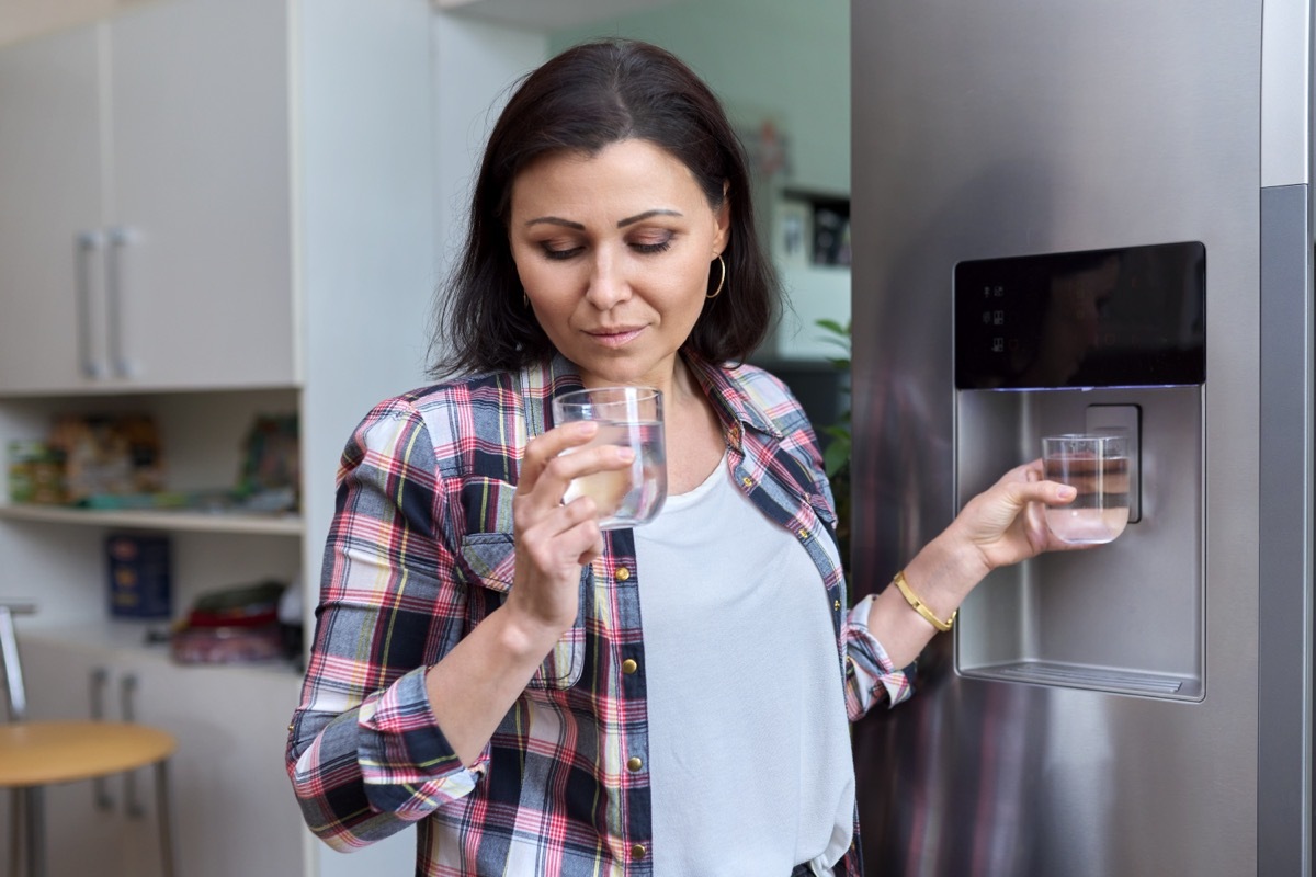 woman drinking water out of a glass