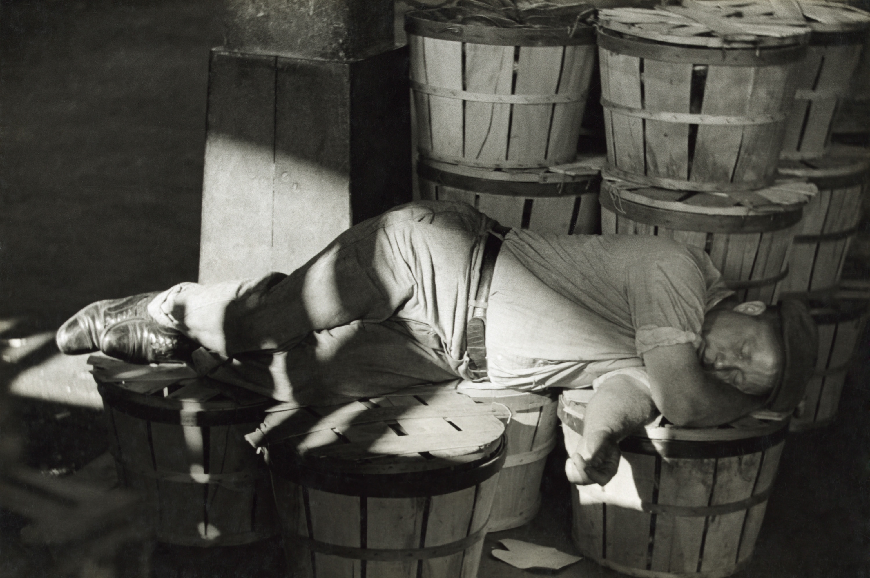 Workman catching a nap at the Baltimore fish market, July 1938.