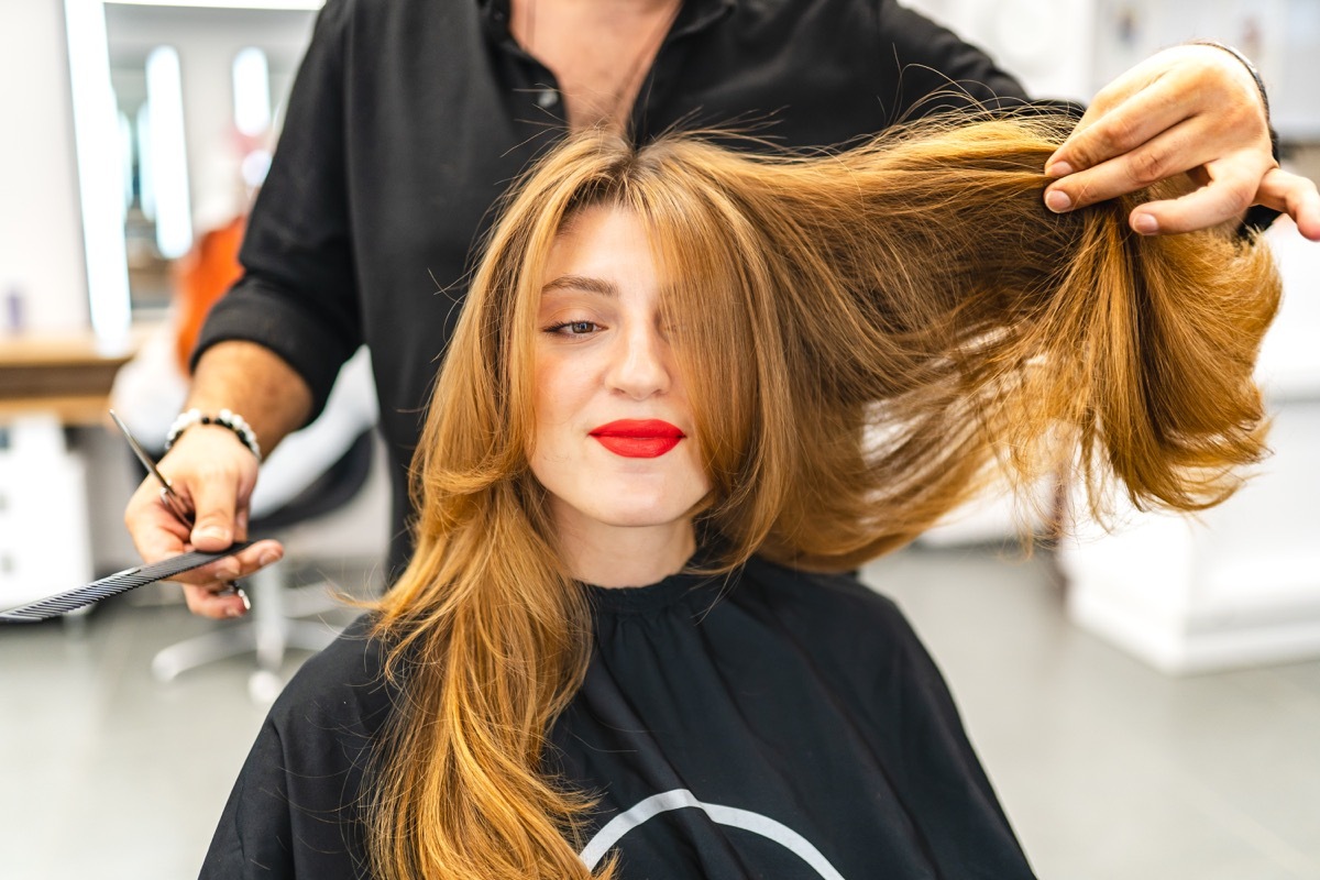 Beautiful young woman getting her hair cut