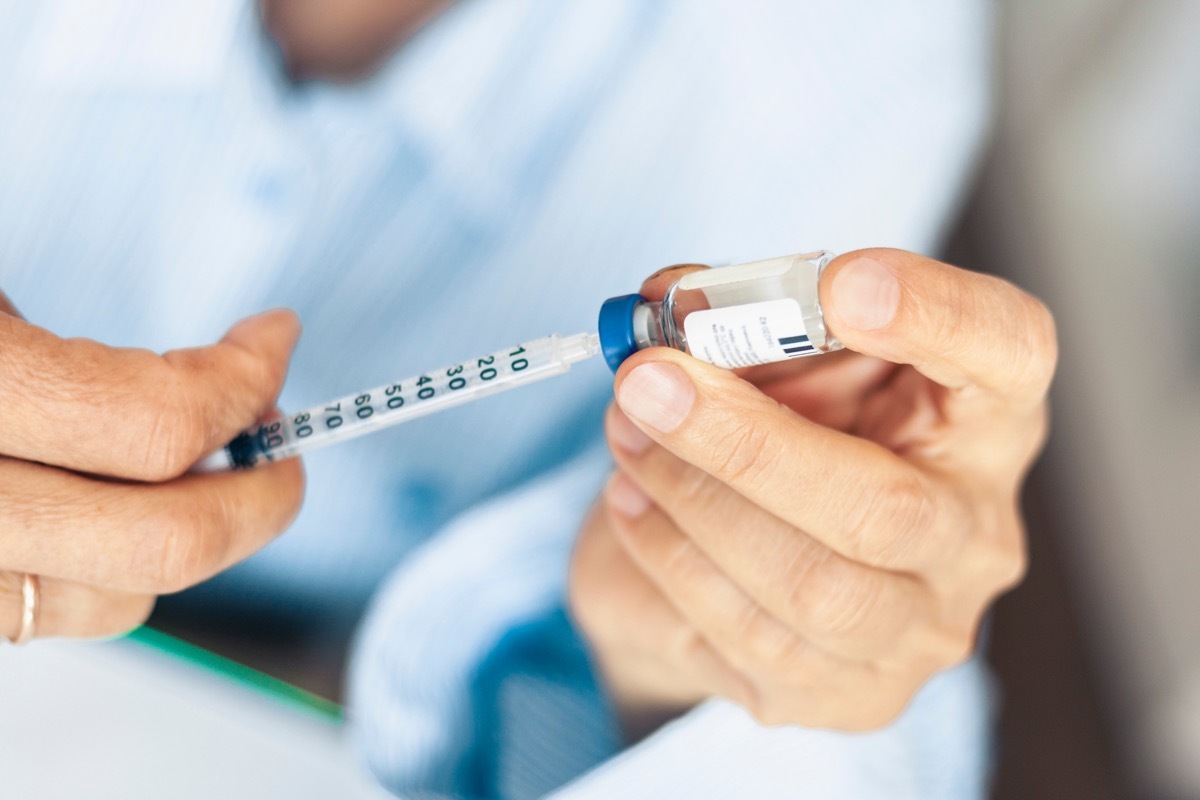 hands holding insulin bottle