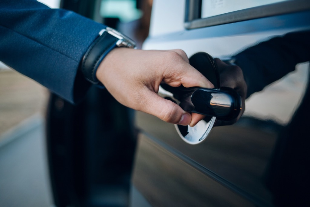 chauffeur opening limo door