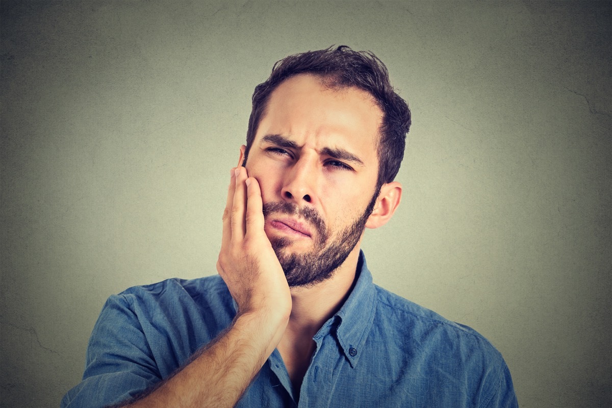 young man with a toothache tooth pain