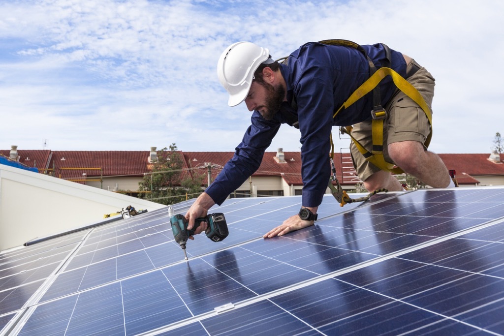 man installing Solar technology on roof