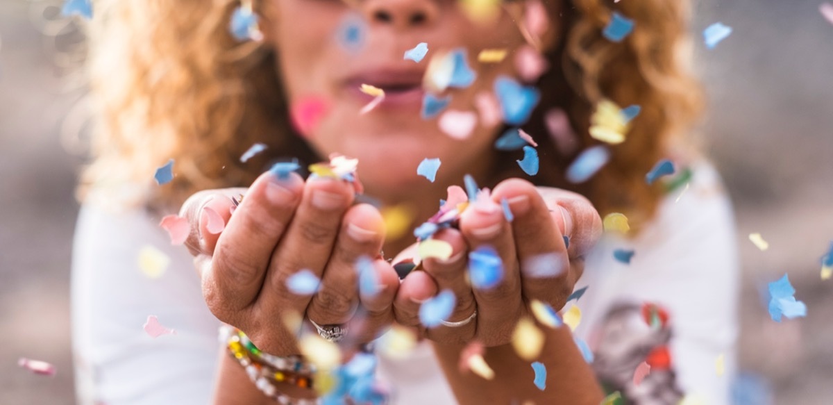 woman blowing birthday confetti