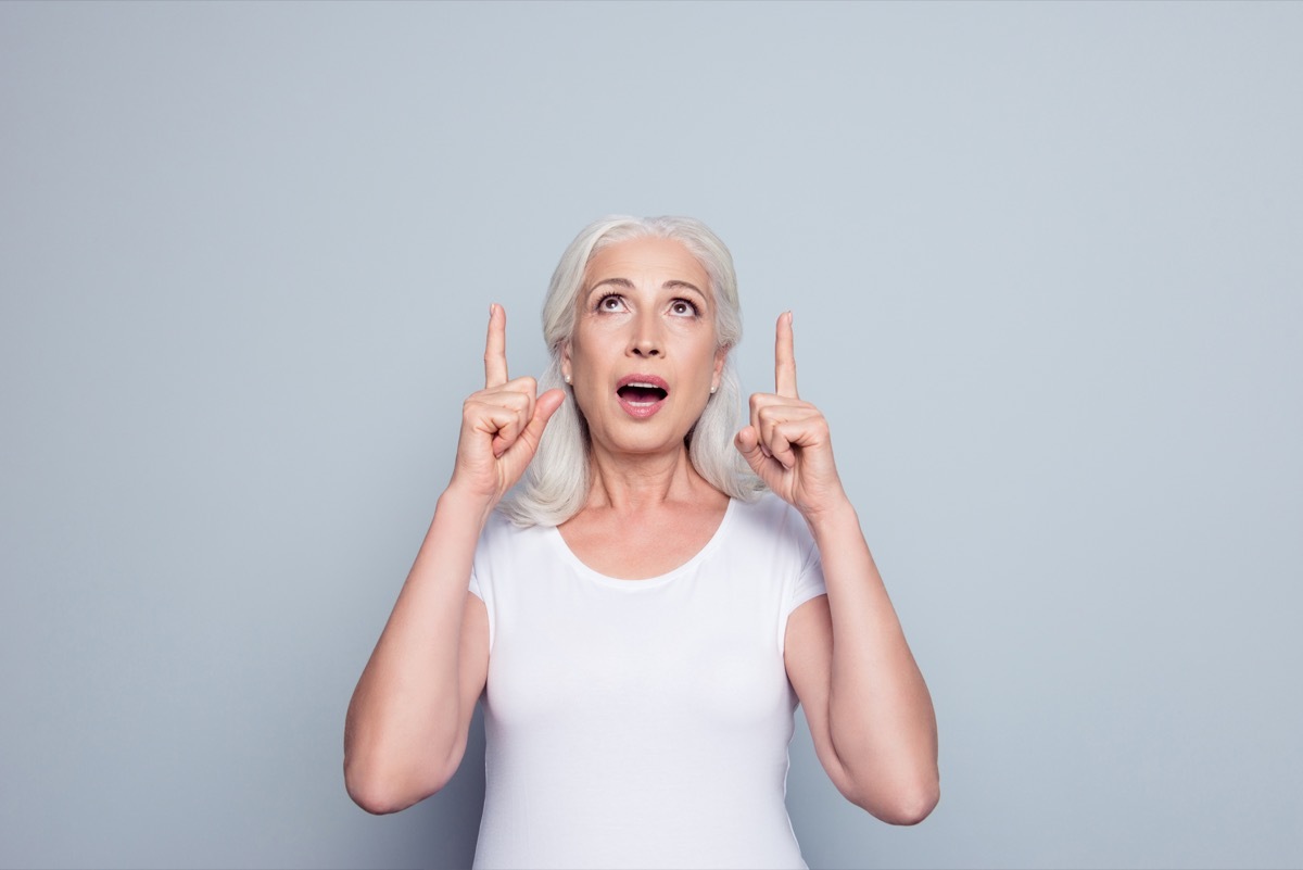 woman in t-shirt demonstrate, looking, pointing with two forefingers up